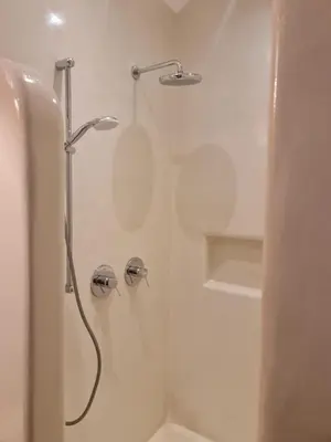 a shower with a shower head in a bathroom at Tilos Villa in Livadia