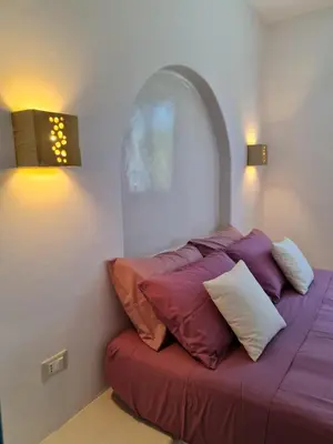 a bed with pillows on it in a room at Tilos Villa in Livadia