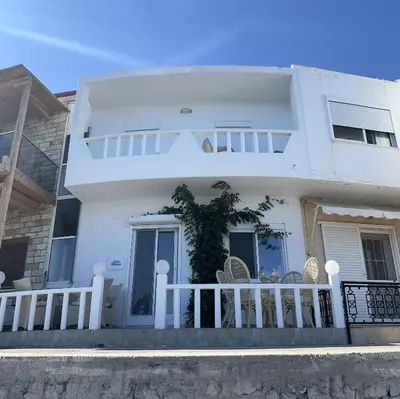 a white house with a porch and chairs at VILLA BLANCA in Haraki