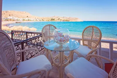 a table and chairs on a balcony overlooking the ocean at VILLA BLANCA in Haraki