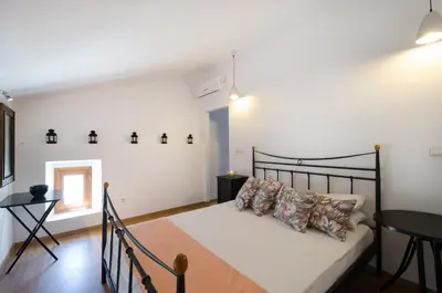 a bedroom with a large bed and a table at Villa Sokaki in Líndos
