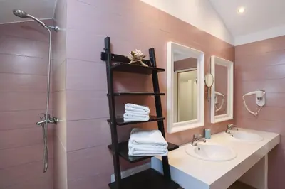 a bathroom with two sinks and two mirrors at Villa Sokaki in Líndos