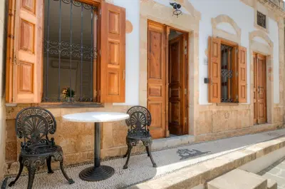 a table and two chairs in front of a building at Villa Sokaki in Líndos