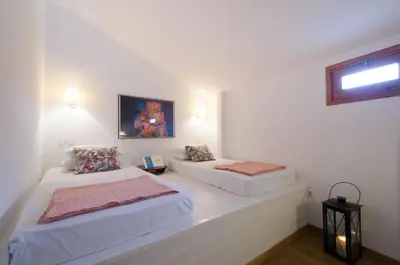 two beds in a room with white walls at Villa Sokaki in Líndos