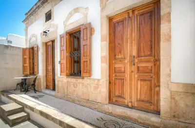 an old building with wooden doors on a street at Villa Sokaki in Líndos