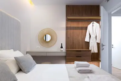 a bedroom with a white bed and a mirror at ANIMA DEL SOL (BASILICO) in Ixia