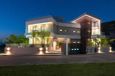 a large house with lights in front of it at ANIMA DEL SOL (BASILICO) in Ixia
