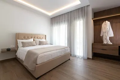 a white bedroom with a large bed and a window at ANIMA DEL SOL (BASILICO) in Ixia