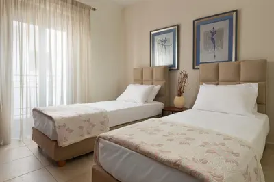 a bedroom with two beds and a window at Casa di Vasia in Gennadi