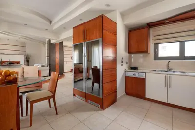 a kitchen with wooden cabinets and a dining room at Casa di Vasia in Gennadi