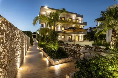 a house with a wooden walkway in front of a building at Sun City Luxury Apartments in Rhodes Town