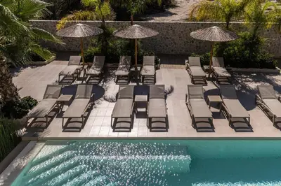 a group of chairs and umbrellas next to a pool at Sun City Luxury Apartments in Rhodes Town