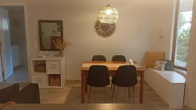 a dining room table with chairs and a mirror at Charming garden apartment in Rhodes Town
