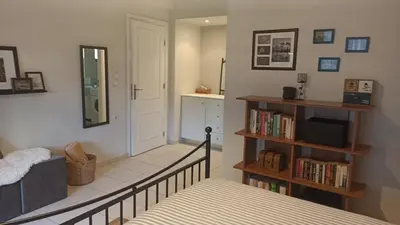 a room with a staircase with a mirror and a book shelf at Charming garden apartment in Rhodes Town