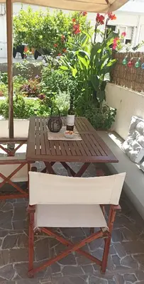 a wooden table and a bench on a patio at Charming garden apartment in Rhodes Town