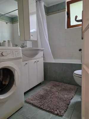 a bathroom with a sink and a washing machine at Charming garden apartment in Rhodes Town