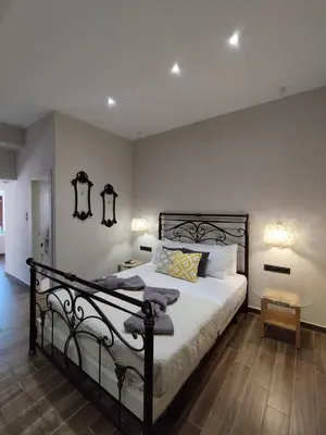 a bedroom with a bed with a black metal frame at Althea Apartments 3 in Halki
