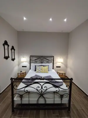 a bedroom with a bed with two lamps on it at Althea Apartments 3 in Halki