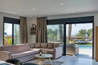 a living room with a couch and a table at Penélope Beachfront Villa in Kremasti
