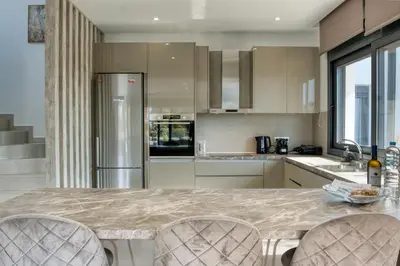 a kitchen with a large marble table and chairs at Penélope Beachfront Villa in Kremasti