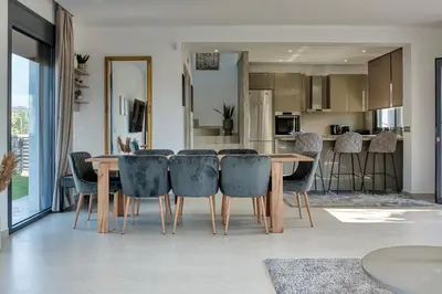 a dining room and kitchen with a table and chairs at Penélope Beachfront Villa in Kremasti