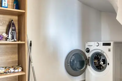 a washing machine in a laundry room with a shelf at Penélope Beachfront Villa in Kremasti