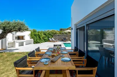 a wooden table with plates and dishes on it on a patio at Villa Heather in Kolimbia
