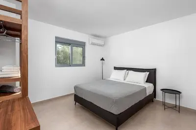 a white bedroom with a bed and a window at Villa Heather in Kolimbia