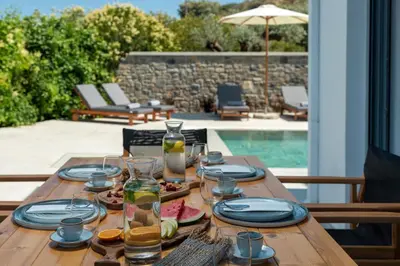 a wooden table with plates and glasses on top of it at Villa Heather in Kolimbia