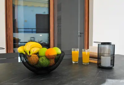 a bowl of fruit on a table with two glasses of orange juice at Borgo Nuovo in Rhodes Town