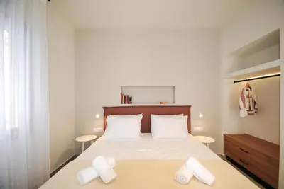 a bedroom with a bed with white sheets and white pillows at Borgo Nuovo in Rhodes Town