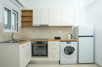 a kitchen with a washing machine and a refrigerator at VOULA APARTMENTS in Faliraki