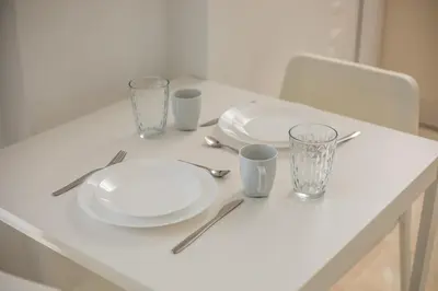 a white table with plates and cups on it at VOULA APARTMENTS in Faliraki