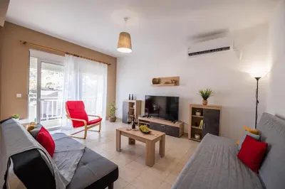 a living room with a couch and a tv at Katerina's House in Afantou