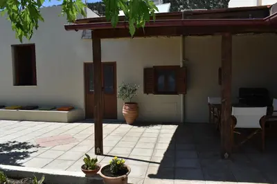 a patio with potted plants in front of a house at Lithos House in Monólithos