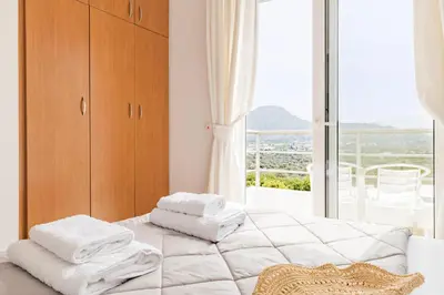 a bedroom with white towels on a bed with a window at Villa Thea in Afantou