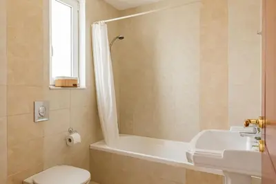 a bathroom with a tub and a toilet and a sink at Villa Thea in Afantou