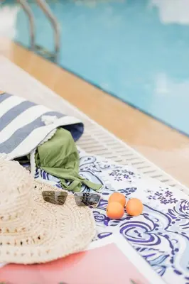 a hat and two oranges on a rug on a floor at Villa Thea in Afantou