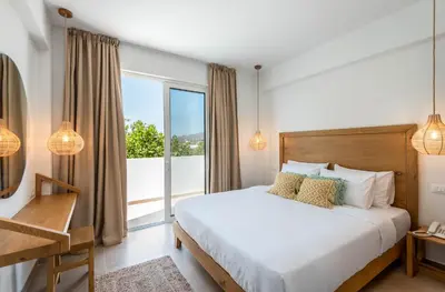 a bedroom with a bed and a large window at Absolute Kiotari Resort in Kiotari