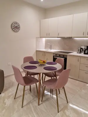 a kitchen with a table and chairs in a room at Ma Maison Rose in Kremasti