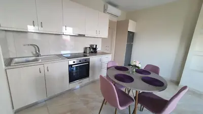 a kitchen with a table and chairs and a sink at Ma Maison Rose in Kremasti