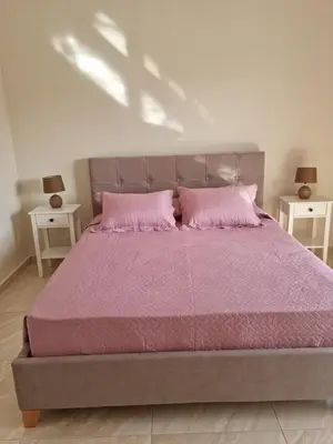 a bedroom with a large bed with pink sheets and pillows at Ma Maison Rose in Kremasti