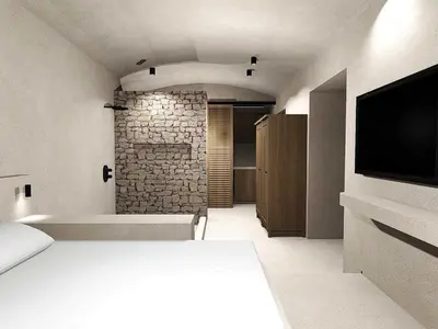 a bedroom with a bed and a stone wall at EliteDIMension Chalki in Halki