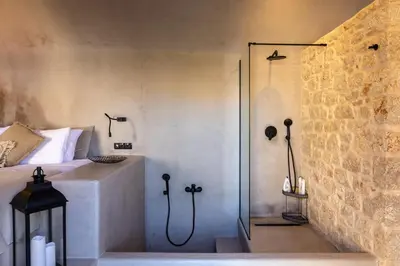 a bathroom with a shower and a bed and a shower at EliteDIMension Chalki in Halki