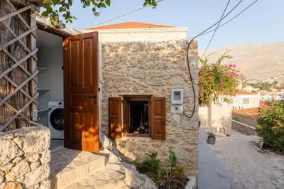 an entrance to a stone house with wooden doors at EliteDIMension Chalki in Halki