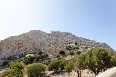 a mountain with a village on top of it at EliteDIMension Chalki in Halki