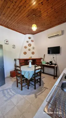 a dining room with a table and a television at Villa Kavalino in Kolimbia