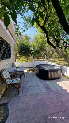 a patio with a hot tub and a table and chairs at Villa Kavalino in Kolimbia