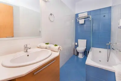 a bathroom with a sink and a shower and a toilet at Villa Kiotari Alia in Kiotari