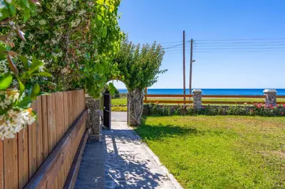 a wooden fence and a pathway with the ocean in the background at Villa Kiotari Alia in Kiotari